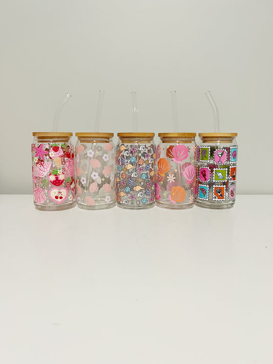Set of five decorative glass jars with floral and patchwork designs on a white background